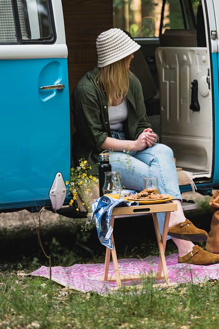 Rebel-Outdoor krukje met houten dienblad voor jonge vrouw in camper